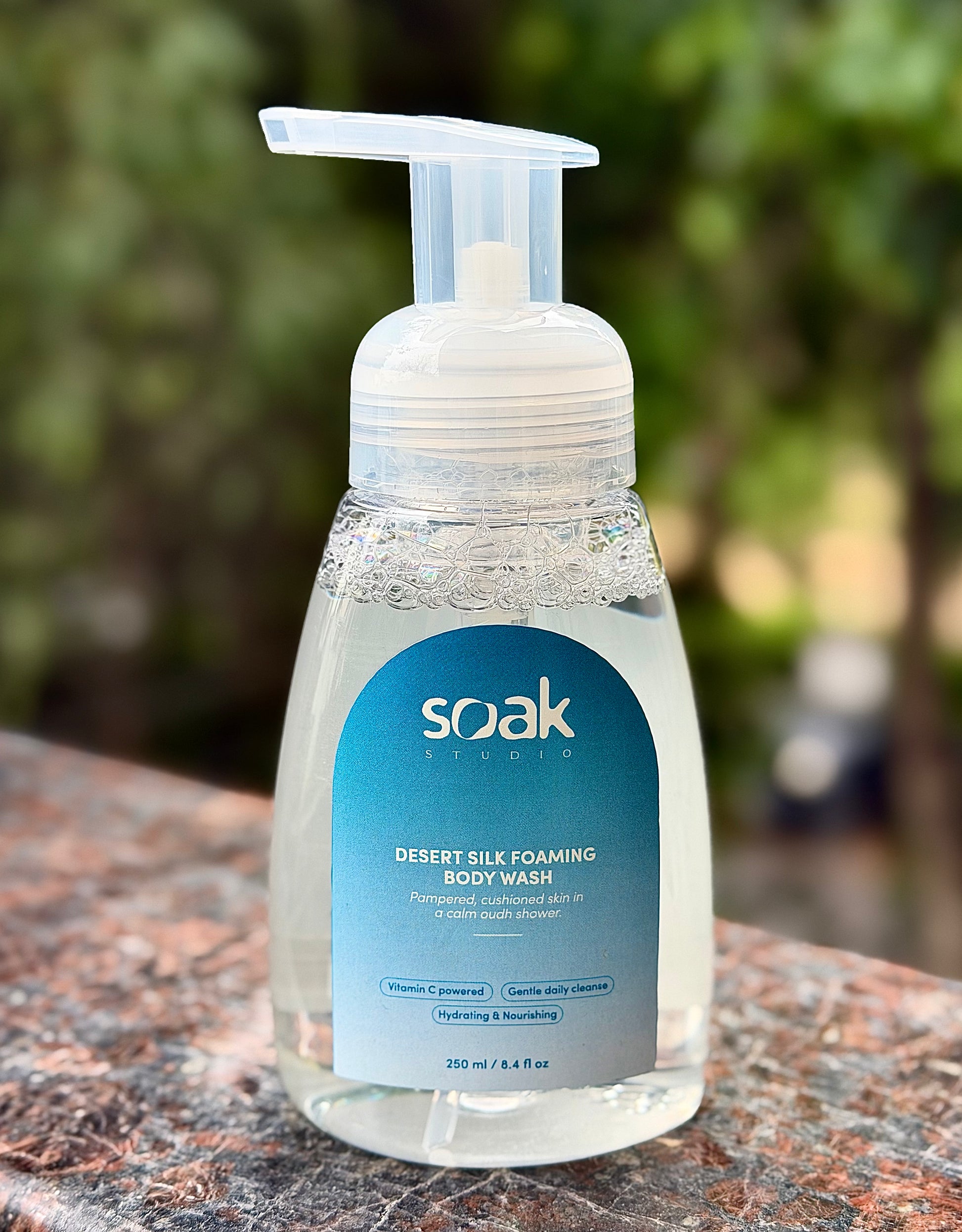Soak Studio Desert Silk on a natural stone surface with a blurred green background.