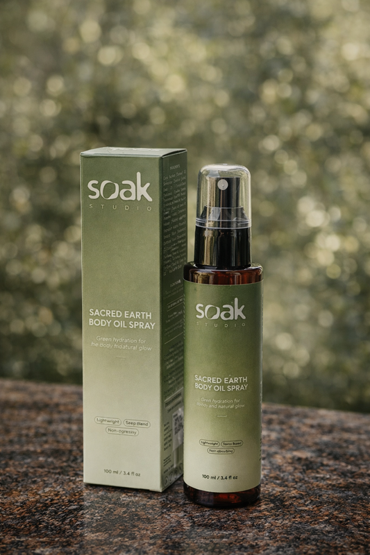 Soak Studio Sacred Earth Body oil spray on a blurred natural background