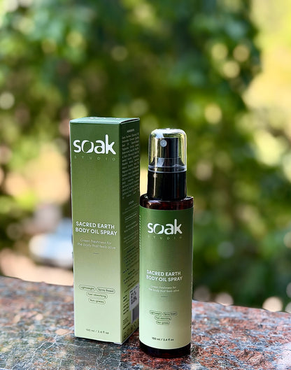 Soak Studio Sacred Earth Body oil spray on a blurred natural background
