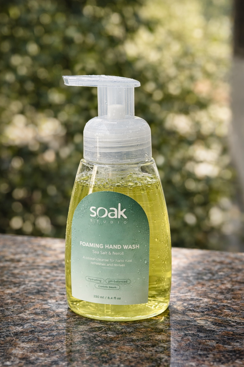 Soak Studio Sea Salt and Neroli foaming hand wash on a surface with a blurred green background