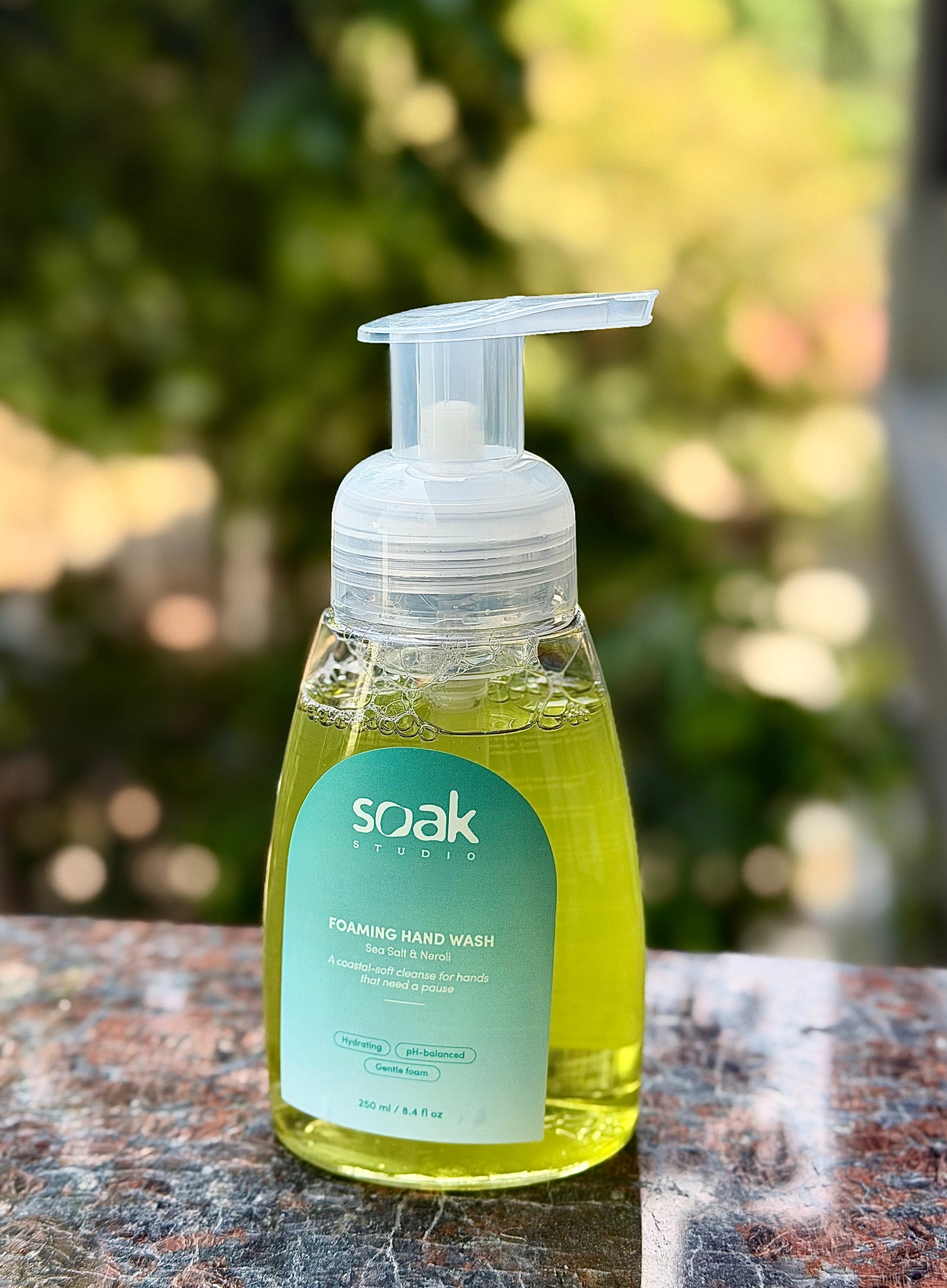 Soak Studio Sea Salt and Neroli foaming hand wash on a wooden surface with a blurred natural background